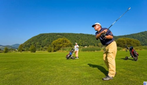 Zwei Menschen die auf dem Golfplatz Golf spielen