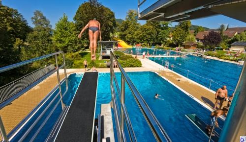 Badespaß Ein Mann springt vom 3 Meterbrett