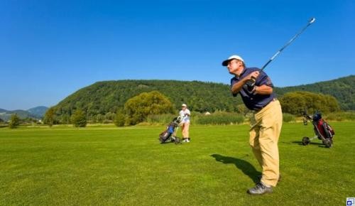 Zwei Menschen die auf dem Golfplatz Golf spielen