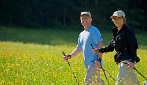 Zwei Nordic Walker auf einer Strecke im Grünen