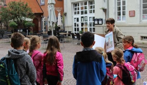Kinderstadtführung Kinderstadtführerinnen und eine Gruppe Kinder in Gewändern mit Leiterwagen
